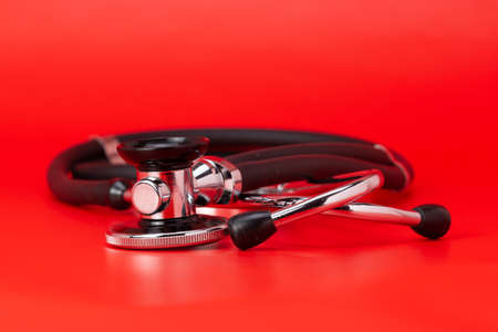 Stethoscope, medical instrument, close-up isolated with red backgroundの写真素材
