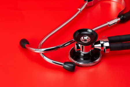 Stethoscope, medical instrument, close-up isolated with red backgroundの写真素材