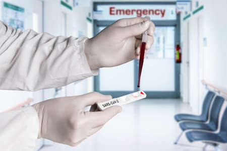 covid-19 -Person holds a test tube with corona virus in hand, in the laboratory