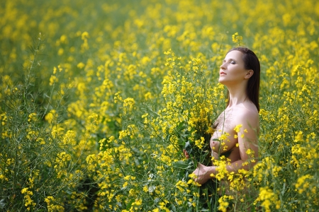 Beautiful topless woman in canolaの写真素材