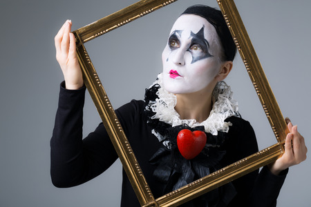 Woman in disguise harlequin in the picture frameの写真素材