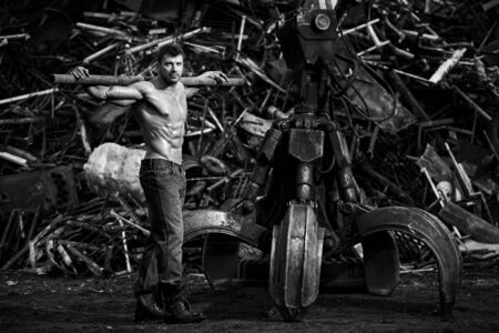Muscular man working on junkyardの写真素材