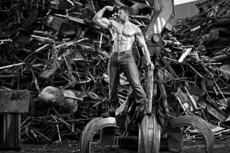Muscular man and heavy equipmentの写真素材