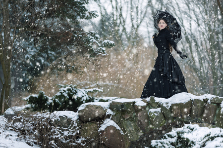 Woman in black Victorian dress in the winter parkの写真素材