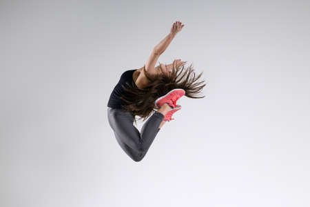 Girl in jump on a gray backgroundの写真素材