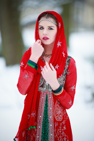 Woman in oriental dress in a winter parkの写真素材