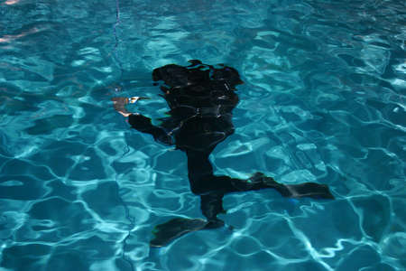 Diver moving underwater with lamp in his hand.の写真素材