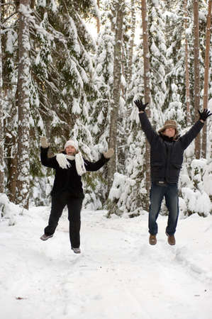 Happy middle-aged couple jumping on a winter day の写真素材