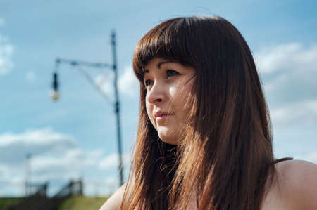 Portrait of young, beautiful woman with blue sky on the background.の写真素材