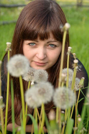 Portrait of young beautiful woman in meadow of dandelions.の写真素材