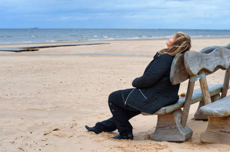 Mature woman relaxing at the Baltic sea in autumn day.の写真素材