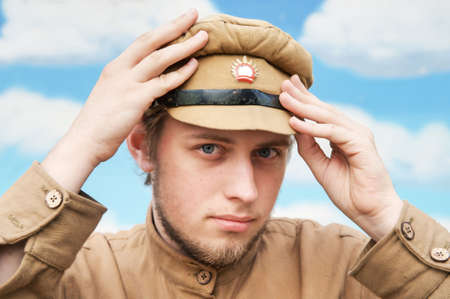 Portrait of soldier in uniform of World War 1 on the background of blue sky. Costume accord the times of World War I. Photo made at cinema city Cinevilla in Latvia. Cockade on the hat do not contain trade mark.の写真素材