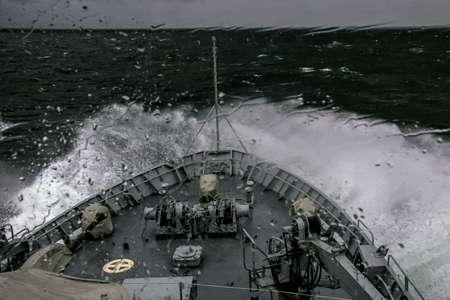 Ship in sea storm. Storm at Baltic sea. Warship training in the Baltic Sea during a storm. NATO military ship in Baltic sea, Latvia. NATO military ship at sea during a storm. view from ships the bow.の写真素材