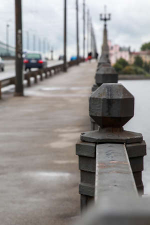 Fragment of Akmens bridge in Riga, Latvia. Stone bridge railings, blurred car traffic in the background. Stone bridge in Riga city.の写真素材