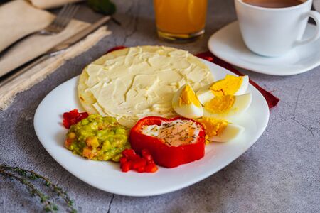 Arepa paisa with eggs, ham and cream cheese. Guacamole as an accompaniment (Colombian breakfast)の写真素材