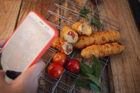 Cheese fingers with sausage inside. Mobile taking a photoの写真素材
