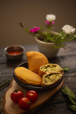 Empanada as breakfast by the window with flowers and sauces