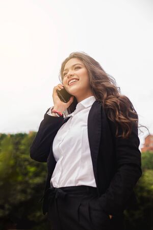 Hispanic woman using cell phone on the streetの写真素材