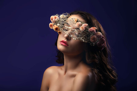 Beautiful young girl with a floral ornament in her hairの写真素材