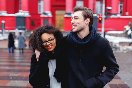 loving couple in a winter day in the city,African girl  and caucasian manの写真素材