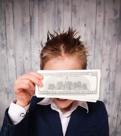 Portrait of happy boy with dollar bills looking at cameraの写真素材