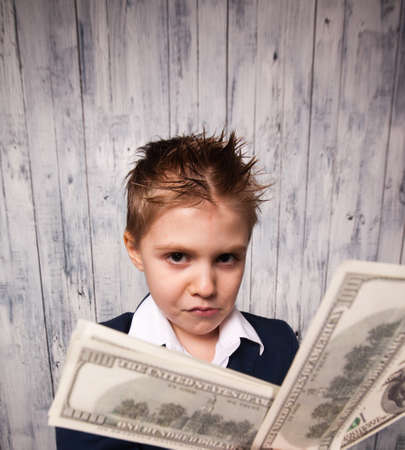 Portrait of happy boy with dollar bills looking at cameraの写真素材
