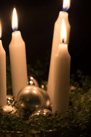 Christmas advent wreath with burning candles laid on table with black backgroundの写真素材