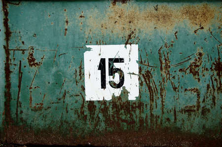 green, partially rusted metal surface with scratched white labelの写真素材