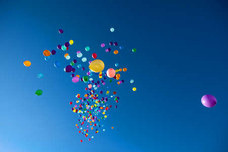 colorful balloons on a blue sky backgroundの写真素材