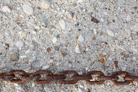 large rusty metal chain on stone wall background