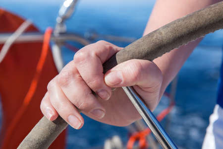 woman drives the boat. hand on the steering wheel closeupの写真素材