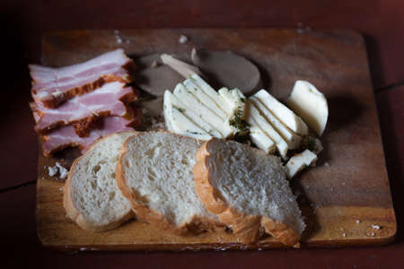 bread meat and cheese on old cutting Board