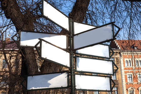 blank white mockup of retro style street advertising column stand on sidewalk. Direction to different places. Information Cityの写真素材