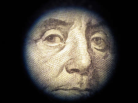 Close-up of Benjamin Franklin, one hundred dollars note. The financial inspector checks falsityの写真素材