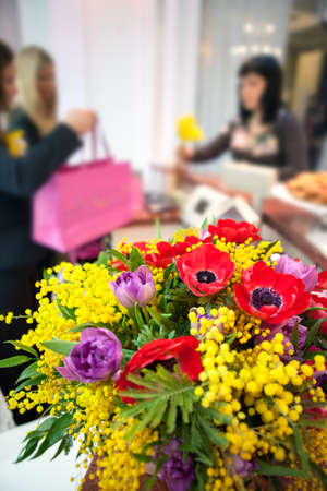 women in the store to make purchases. bouquet of flowers in the foregroundの写真素材