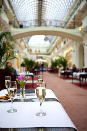 Glasses with champagne on the tables in the restaurantの写真素材