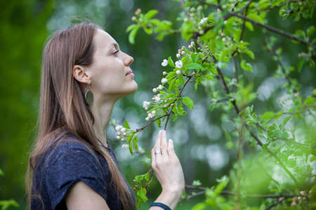 Girl sniffing and enjoying a blossoming tree in the springの写真素材