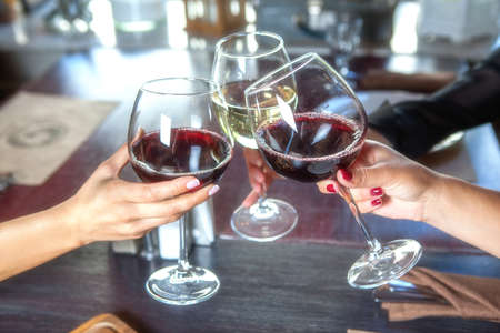 happy friends in a bar drinking red wine.の写真素材
