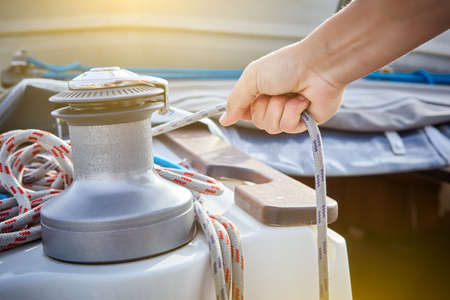 Winch and sailor's hands on sailboat.の写真素材