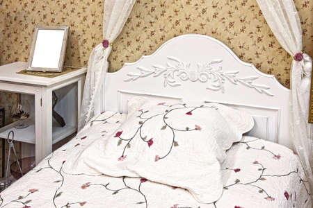 Bedroom modern room with bed in light colors with photo frame for photo on dresser with copy spaceの写真素材