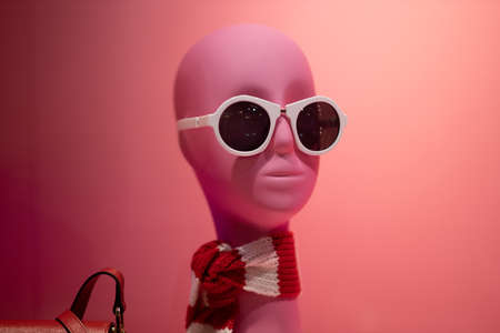mannequin of a woman with white glasses on a pink backgroundの写真素材