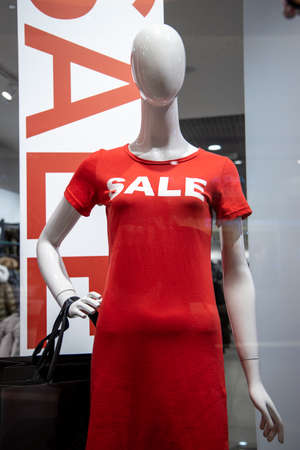 some mannequins wear a red shirt with the word "sale" in the window of an Italian clothing and fashion store. During the winter sales in January.の写真素材