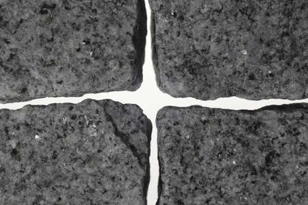 Between four granite stones from a light cross is formed.の写真素材