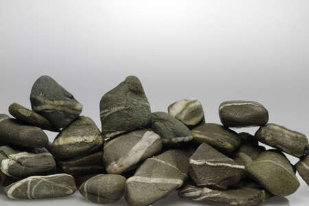 Grey pebbles are piled into a small wall.