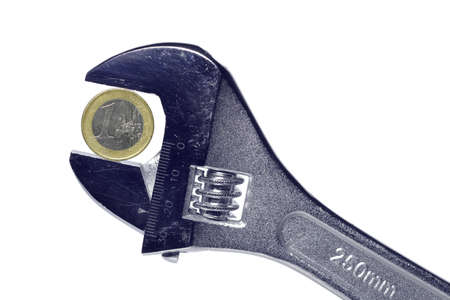 A euro coin is squeezed into a spanner.の写真素材