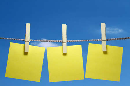 At a cord hanging three clothespins with a sticky note.