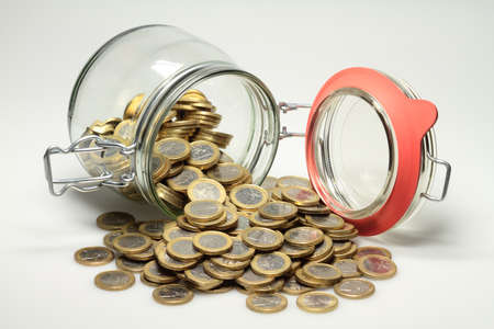 From a jar euro coins are distributed の写真素材
