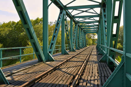 Old railway bridge with truss structure and bottom-mounted roadway 