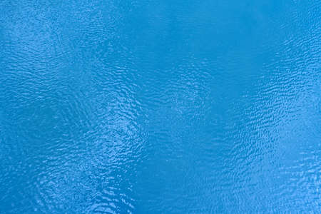 White clouds reflecting in the moving blue water の写真素材