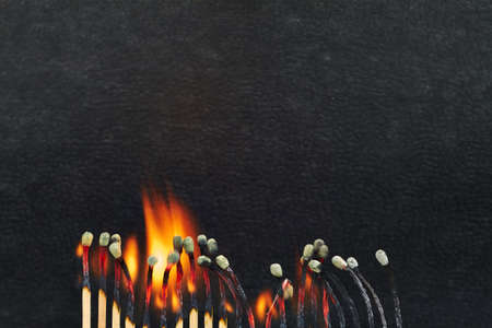A series of matches are next to each other, which burn one after another 